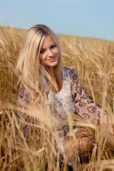 woman sitting on wheat field