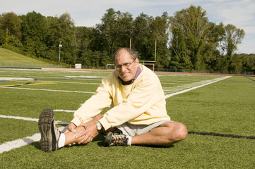 middle age senior man exercising on sports field