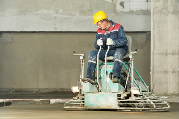 Worker trowelling and finishing of concrete