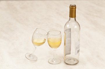 Two white wineglasses with wine bottle