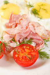 fried eggs with bacon and vegetables