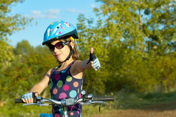 Fototapeta na wymiar Happy girl cycling outdoors. Child on bicycle