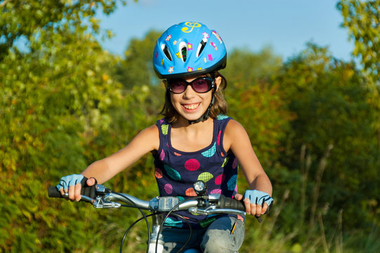 Happy girl cycling outdoors. Child on bicycle