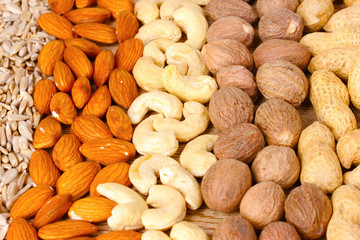 nutmeg, peanuts, hazelnuts and almonds on wooden background