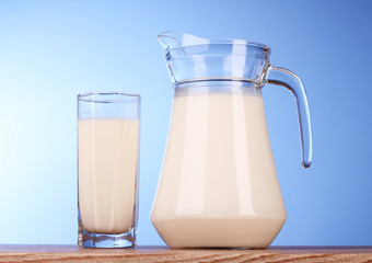 Pitcher and Glass with milk on blue background