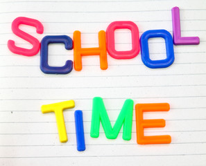 School time in colorful toy letters on lined paper background