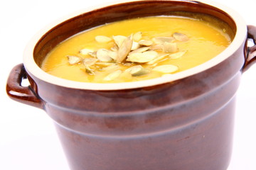 Bowl of pumpkin soup on white background