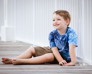 Portrait of happy young boy on beach boardwalk