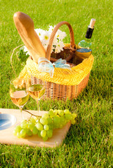 glasses of white wine and picnic on the grass