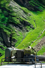 Tourists baggage on car trunk over mountains landscape