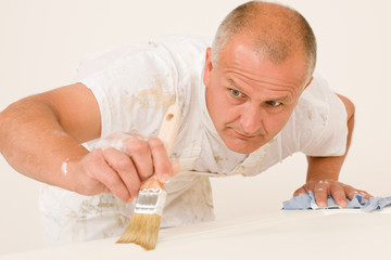 Home decorating mature man painting door brush