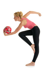 Woman standing with the ball makes the exercise
