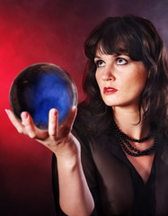 Naklejka premium Young woman with crystal ball.