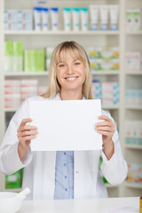 lächelnde apothekerin zeigt weißes schild