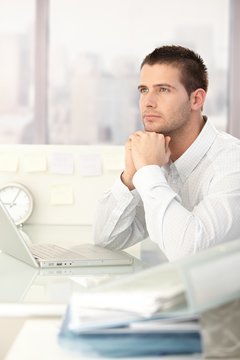 Daydreaming businessman sitting at desk