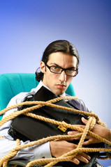 Young businessman tied with rope