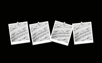 Fototapeta premium Spartiti musicali appesi con puntine da disegno su fondo nero