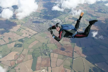 Tuinposter Skydiver in freefall high up in the air © Joggie Botma