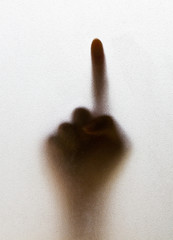 Shadow of a blurry hand behind the frosted glass