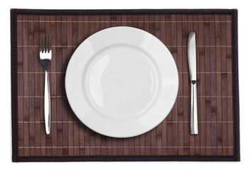 Bamboo placemat with plate fork and knife isolated on white