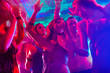 Party people dancing in disco or club