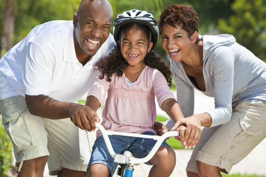 African American Family WIth Girl Riding Bike & Happy Parents