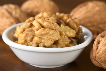 Walnut halves (lat. Juglans regia) in white bowl