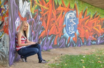 fille avec ordinateur portable sur fond de graffiti