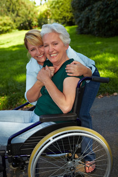 Pflegerin umarmt Seniorin