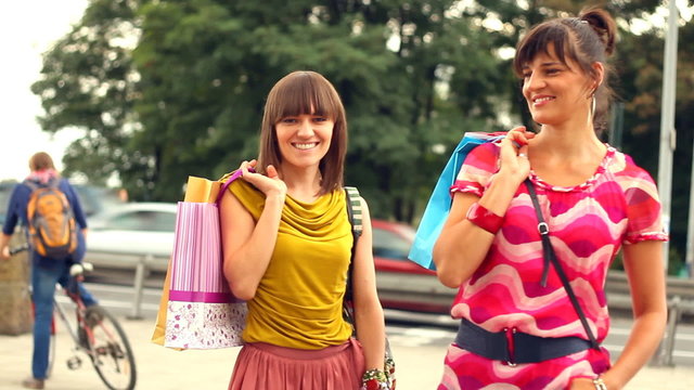 Female friends with shopping bags in the city, steadycam shot
