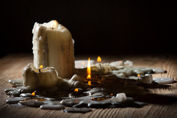 Fototapeta premium Melting candls with fire on wooden shelf