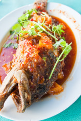 Fried grouper fish with sauce,sour and spicy on white plate,Thai