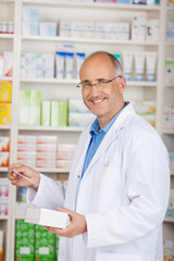 lächelnder apotheker vor dem regal