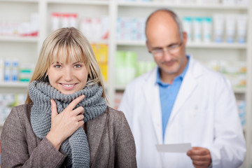 lächelnde kundin mit schal in der apotheke