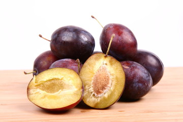 Plums on white background - one cut in half