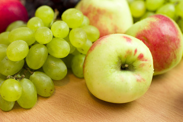 Fresh fruits, apples, grapes and peaches on the table