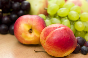 Fresh fruits, apples, grapes and peaches on the table