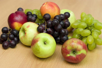 Fresh fruits, apples, grapes and peaches on the table