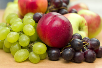 Naklejka na ściany i meble Fresh fruits, apples, grapes and peaches on the table