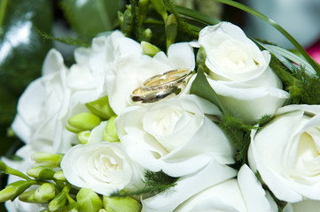 Obraz na płótnie Canvas Wedding rings on white roses