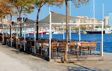 Obraz premium restaurant on a terrace on quay in port of barcelona, spain, cat