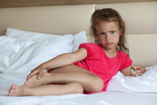Angry little girl lying on the bed.