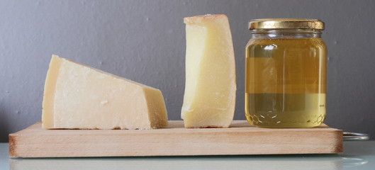 Forme di formaggi italiani e miele di acacia