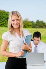 Businesswoman in sunny nature with folders smile