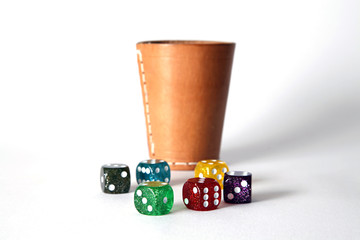 Würfel mit Würfelbecher im Hintergrund