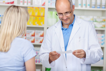 Obraz premium freundlicher apotheker liest ein rezept