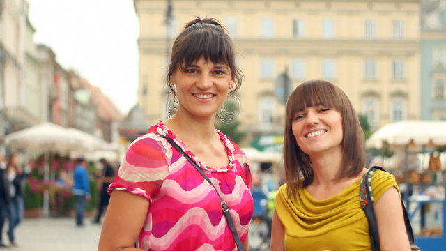 Two happy women with shopping bags in the city, steadycam shot