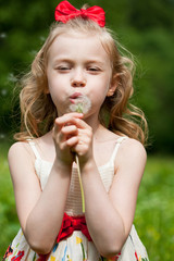 Portrait of the beautiful little girl with a dandelion