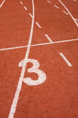 Number three on the start of a running track