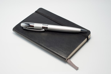caderno preto e caneta